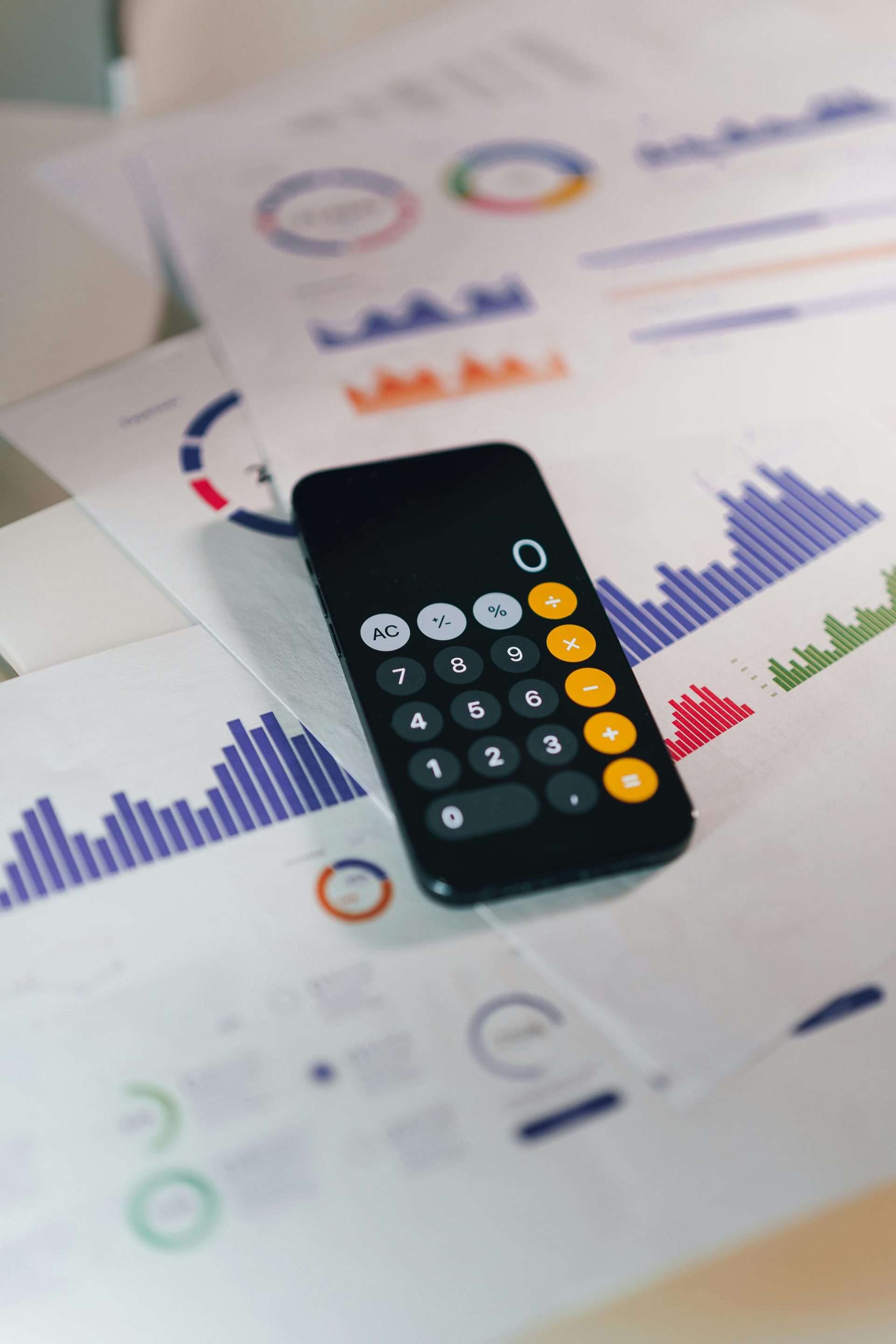 Rechner auf Diagrammen, die Finanzdaten und Analysen anzeigen. Ideal für Geschäfts- und Finanzthemen.
