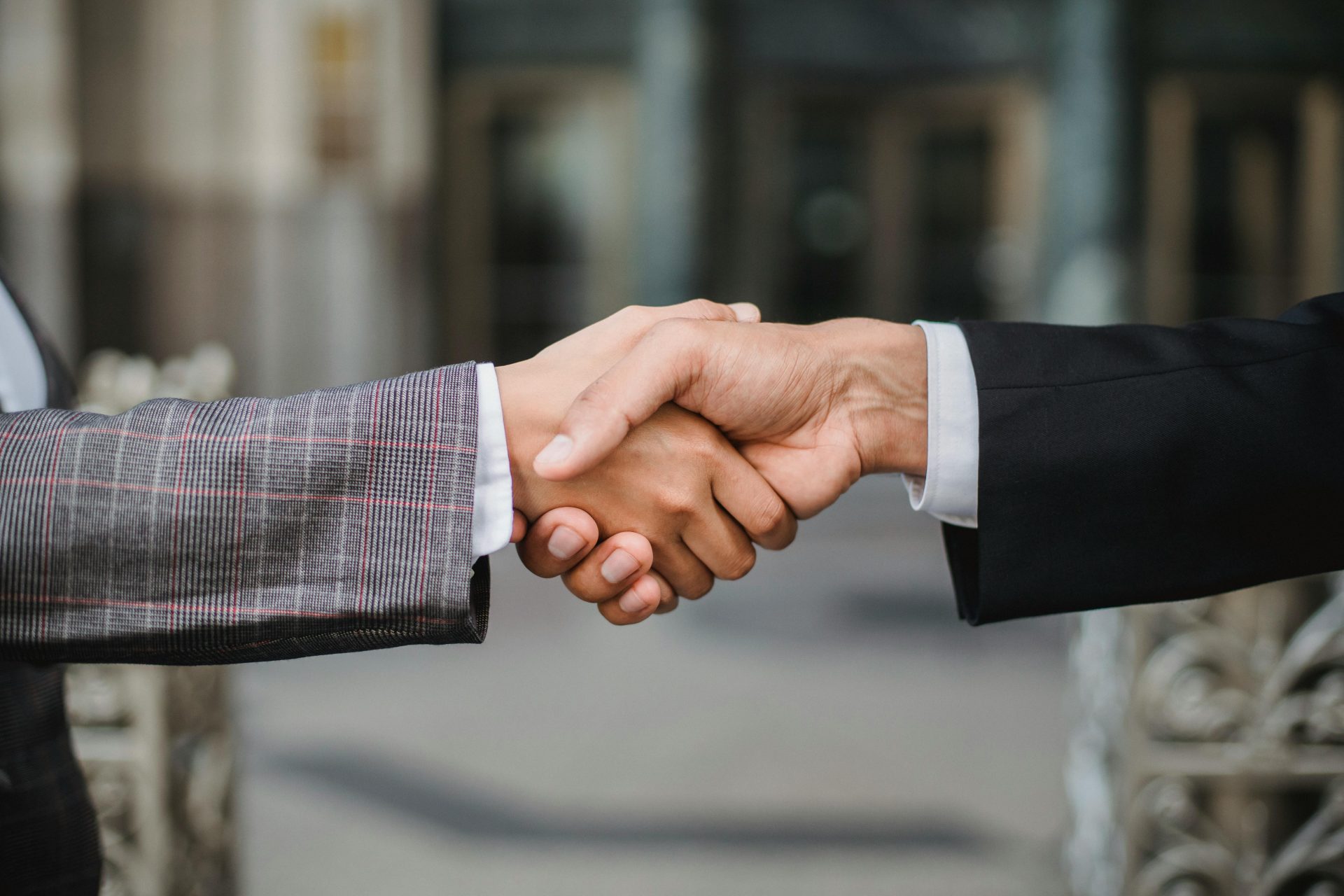 Eine Nahaufnahme von zwei Geschäftsleuten, die sich die Hand geben und so Zusammenarbeit und Partnerschaft symbolisieren.
